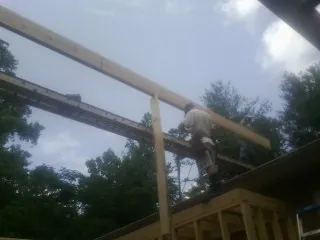 Carpenter setting a ridge beam over a new addition frame — Ice Dam Removal by Roofing Brothers in Dubuque