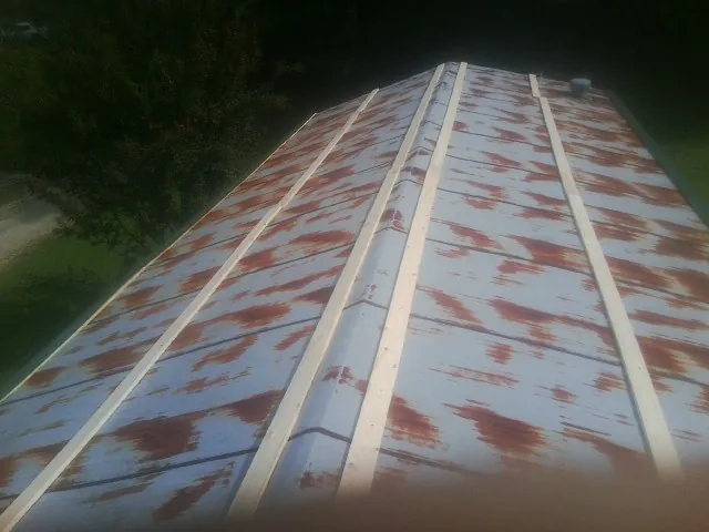 Rusted metal roof panels with new wood purlins before replacement — Storm Damage Roof Repair in Dubuque by Roofing Brothers