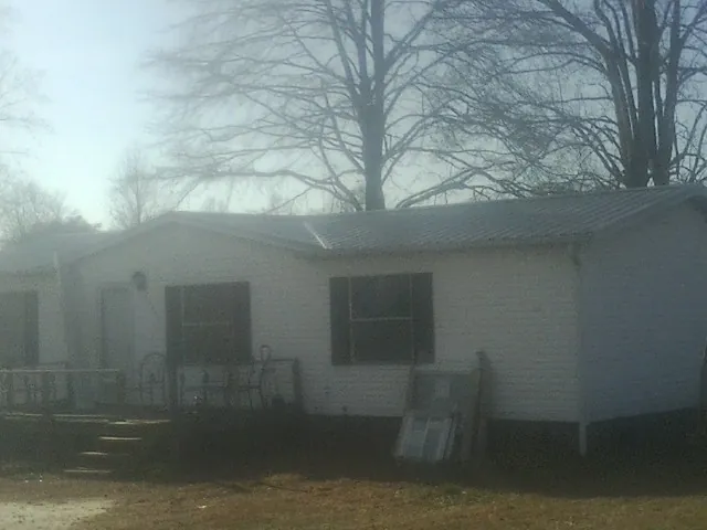 New metal roof on a white painted brick home on a foggy morning in Dubuque
