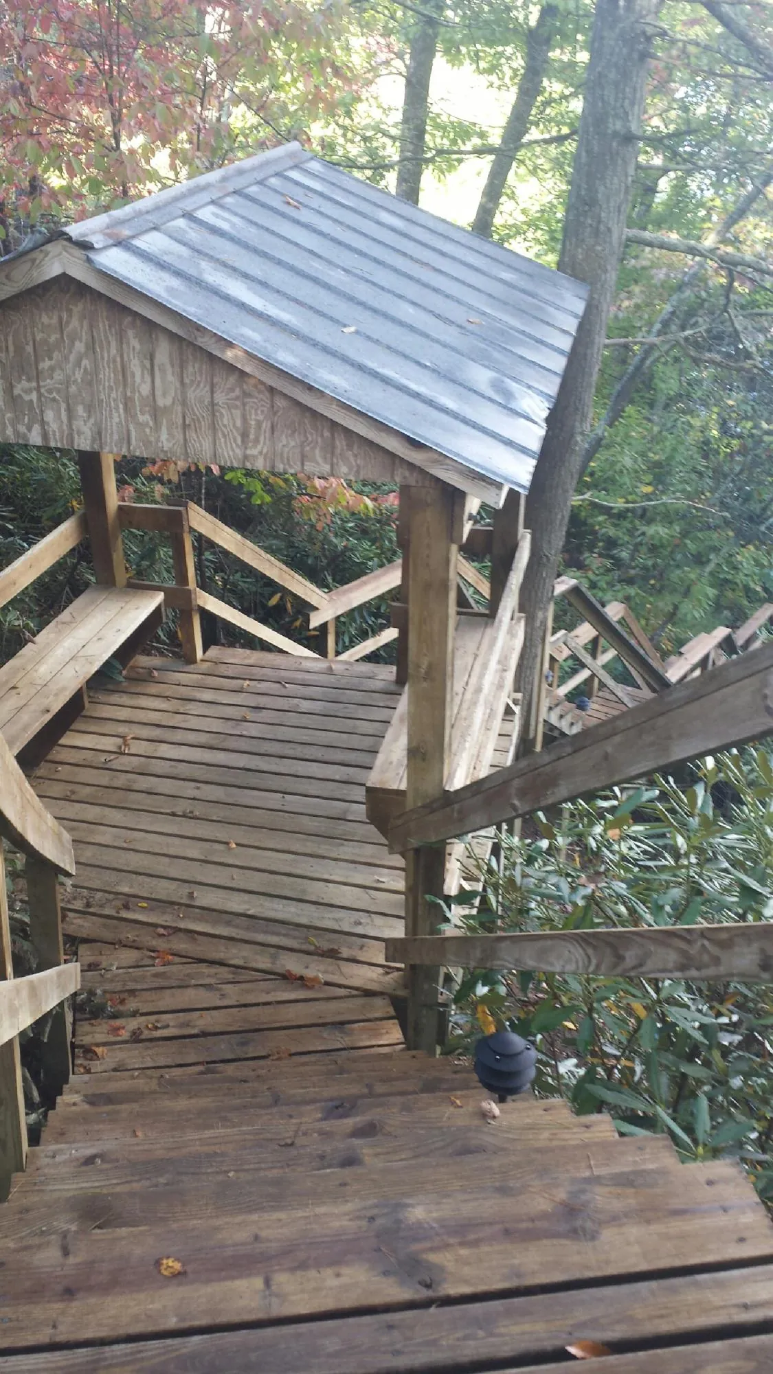 Metal roofed shelter over wooden steps on a wooded walkway — Skylight Repair & Installation work by our crew in Dubuque