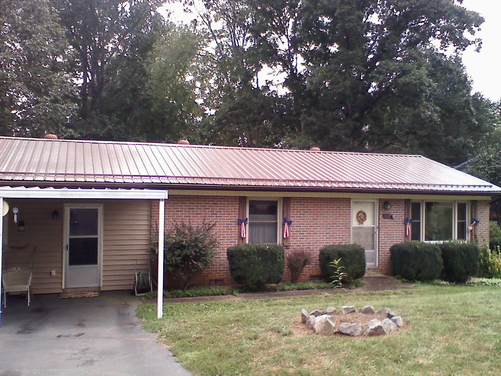 Bronze metal roof and carport on a brick ranch home — Roof Repair work by our crew in Dubuque
